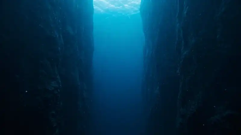 Ethereal light shafts fade into a vast, dark oceanic abyss