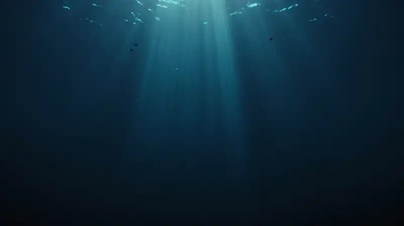 Tiny silhouettes drift through a vast, dark oceanic abyss